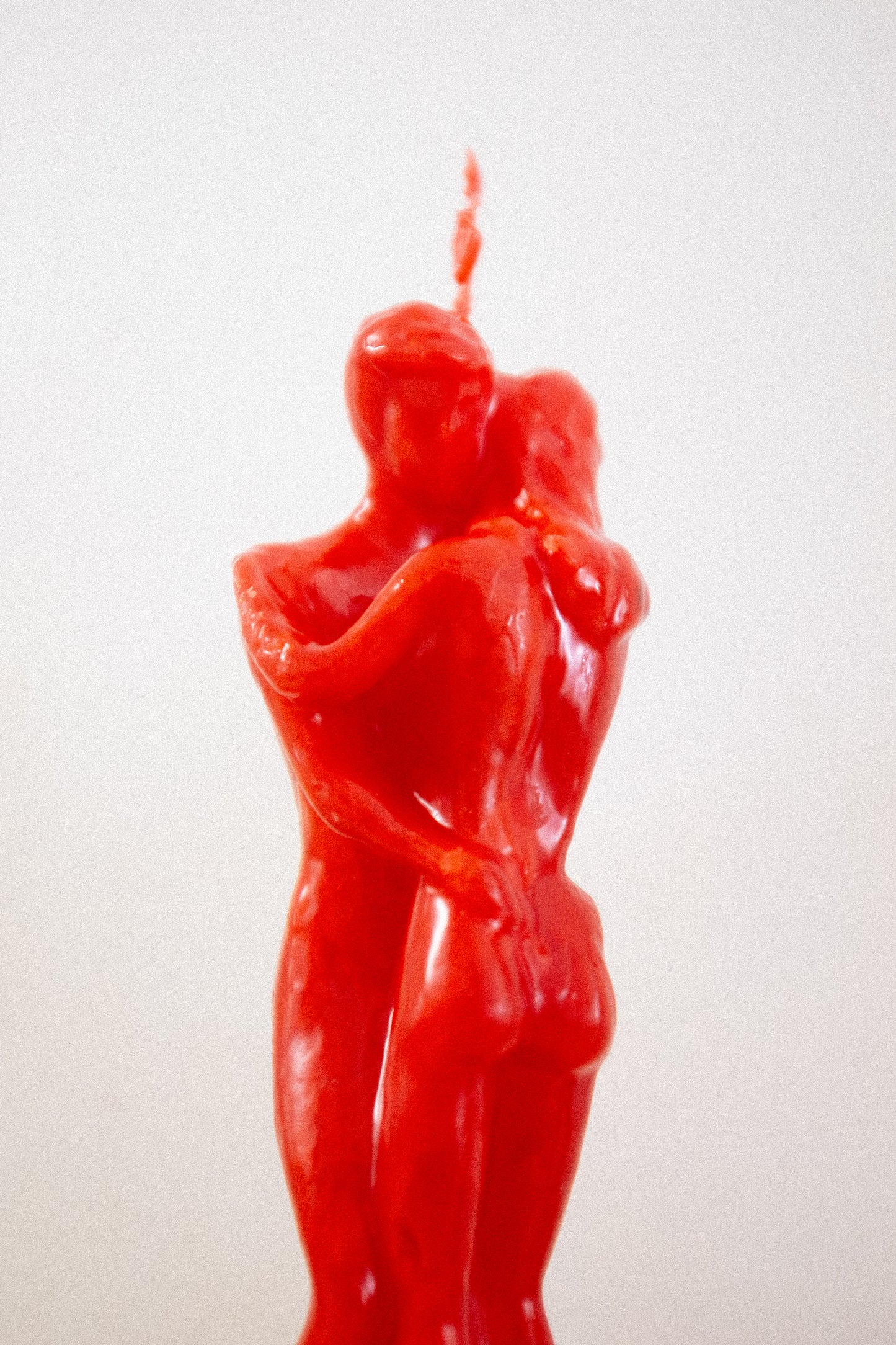 Red honey scent candle shaped like a couple embracing with a white background
