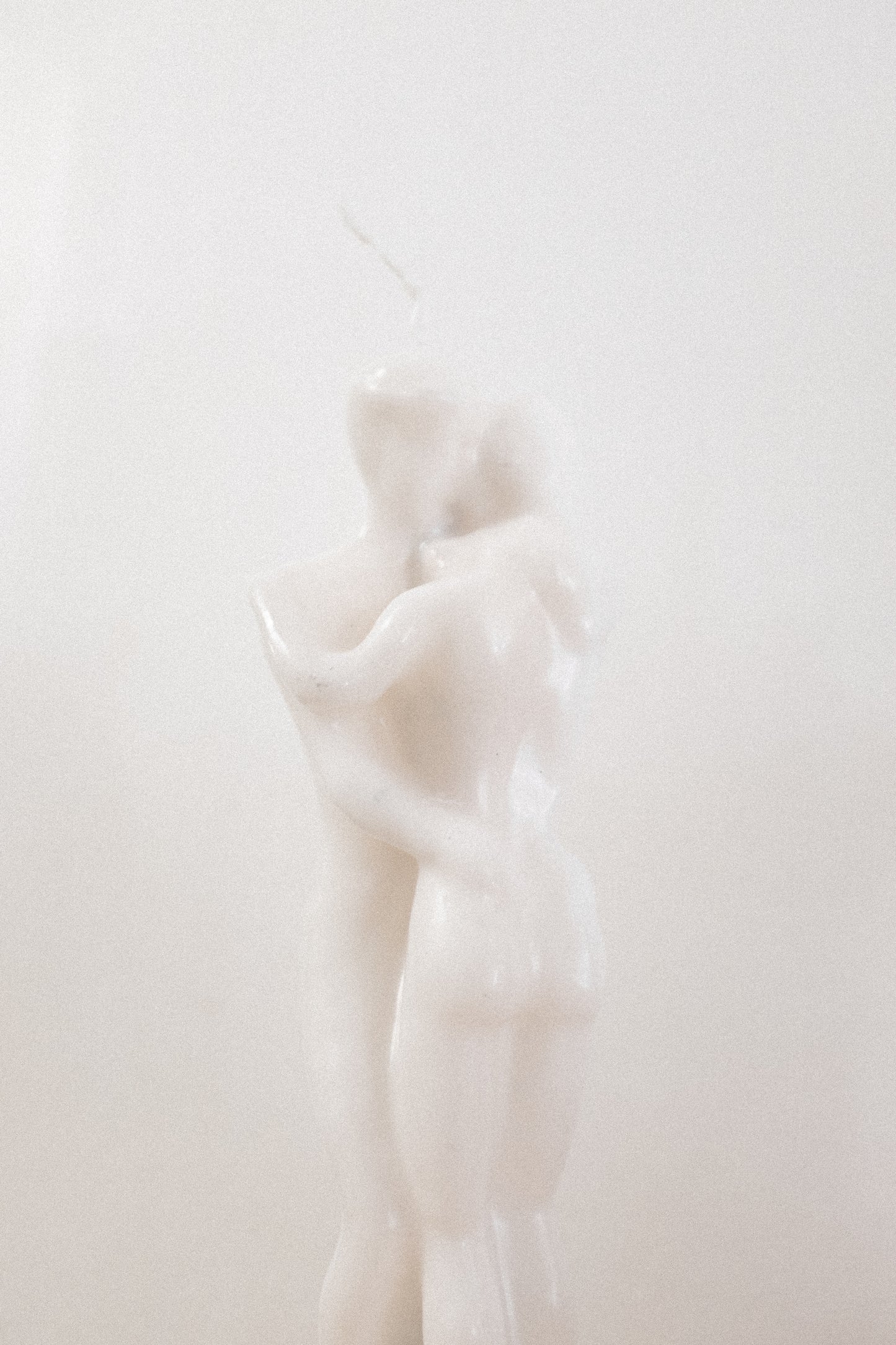 White honey scent candle shaped like a couple embracing with a white background