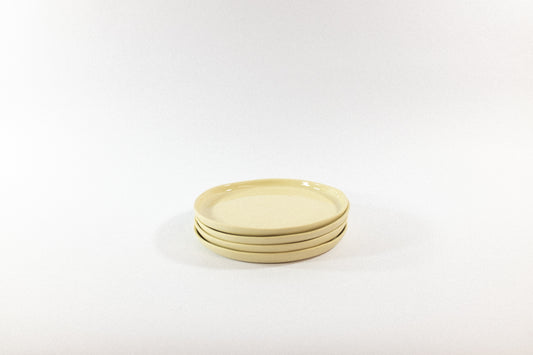 Handmade cream desser plates stacked on a white background
