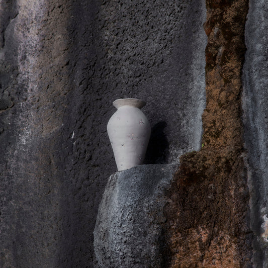 Handmade big funfetti stoneware vase on the textured stone wall