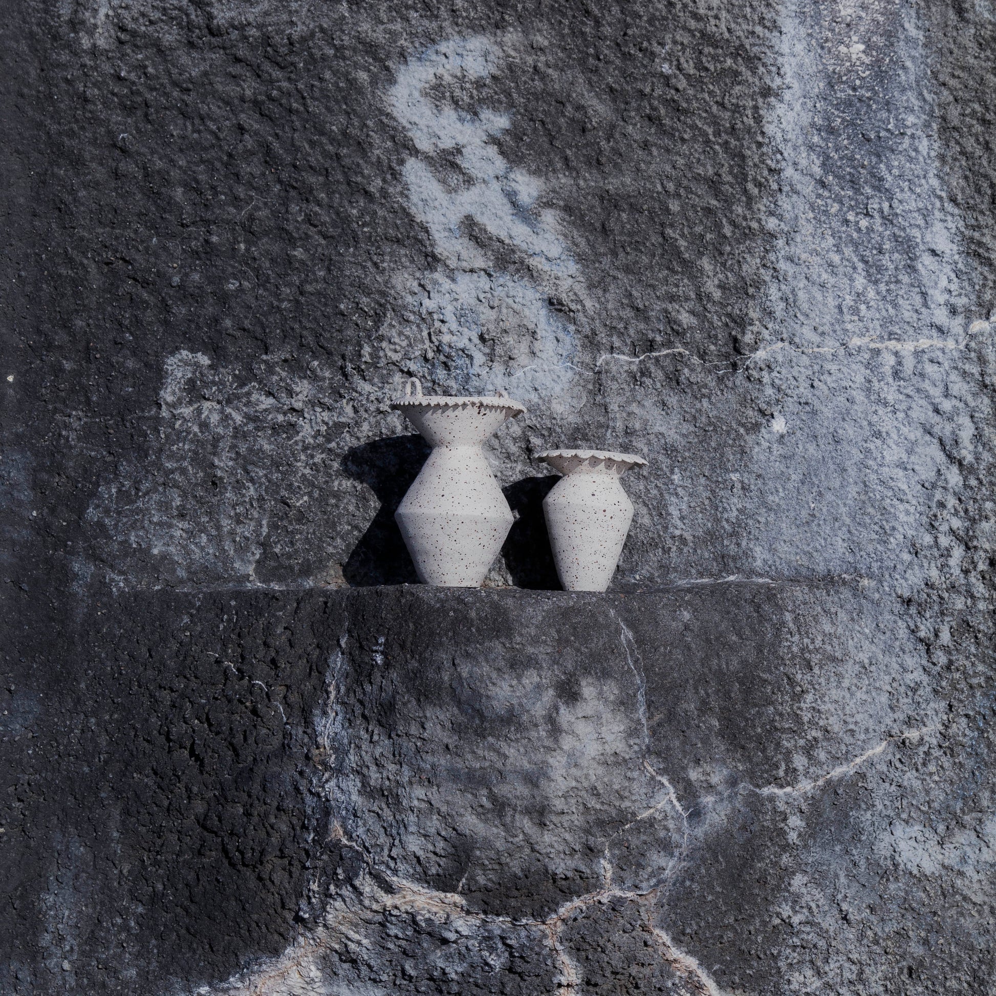 Handmade two stoneware vases with textured surface on a gray stone background