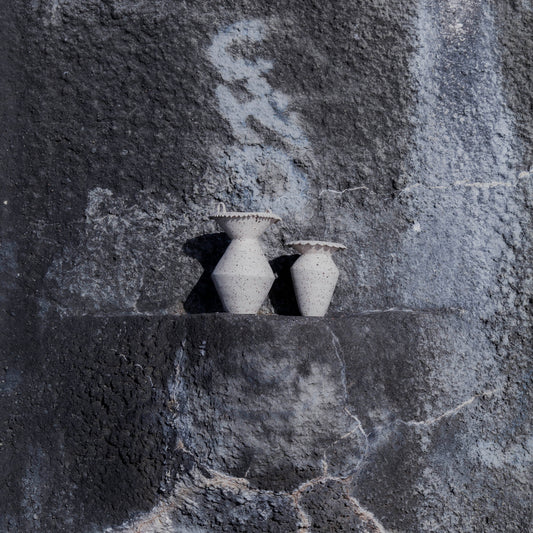 Handmade two stoneware vases with textured surface on a gray stone background