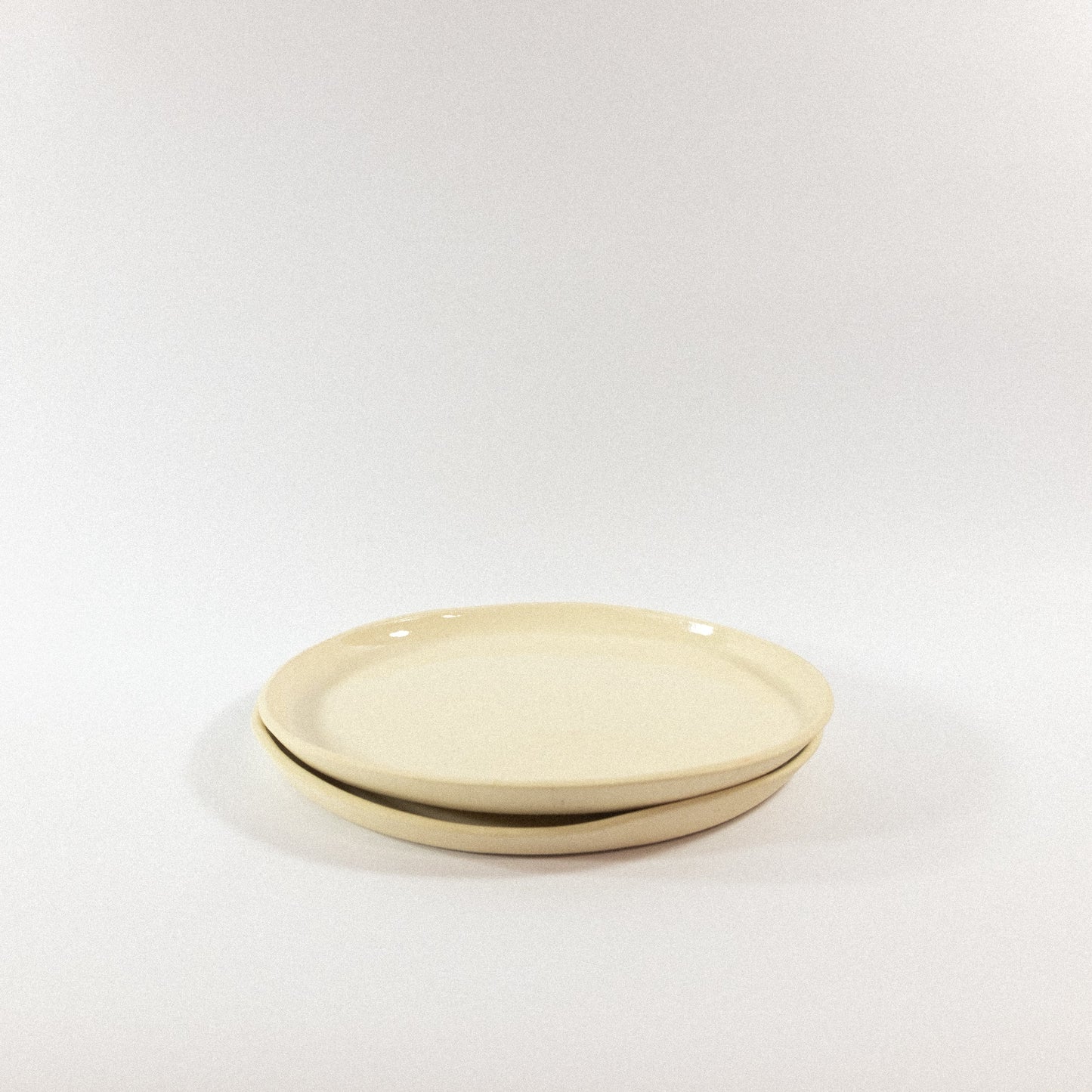 Handmade small porcelain dinner plates on a white background