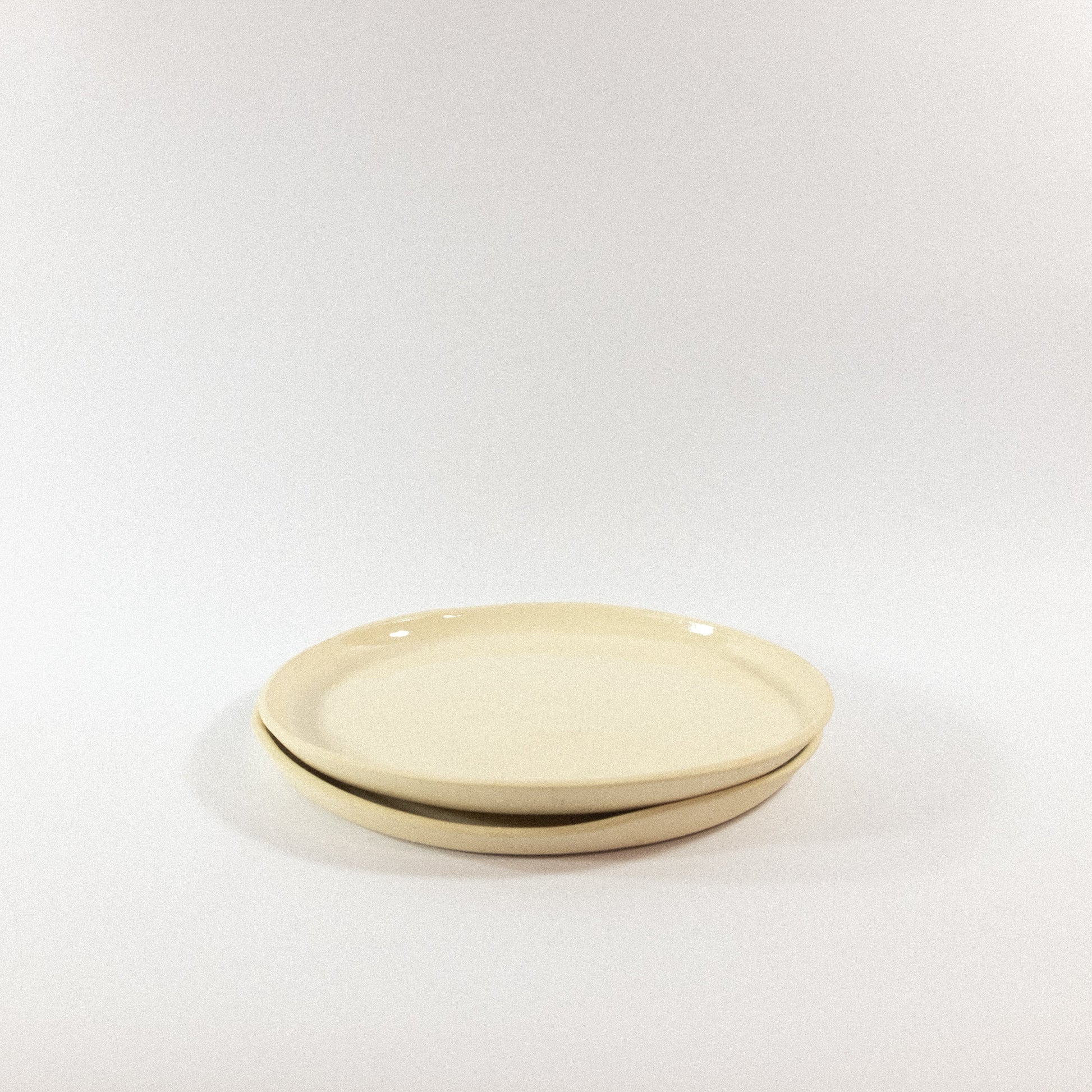 Handmade small porcelain dinner plates on a white background
