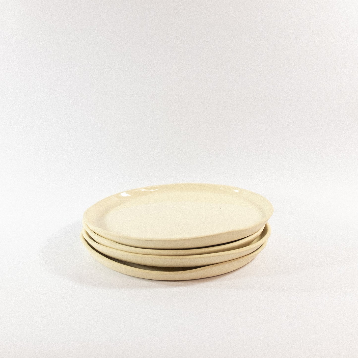 Handmade small porcelain dinner plates on a white background