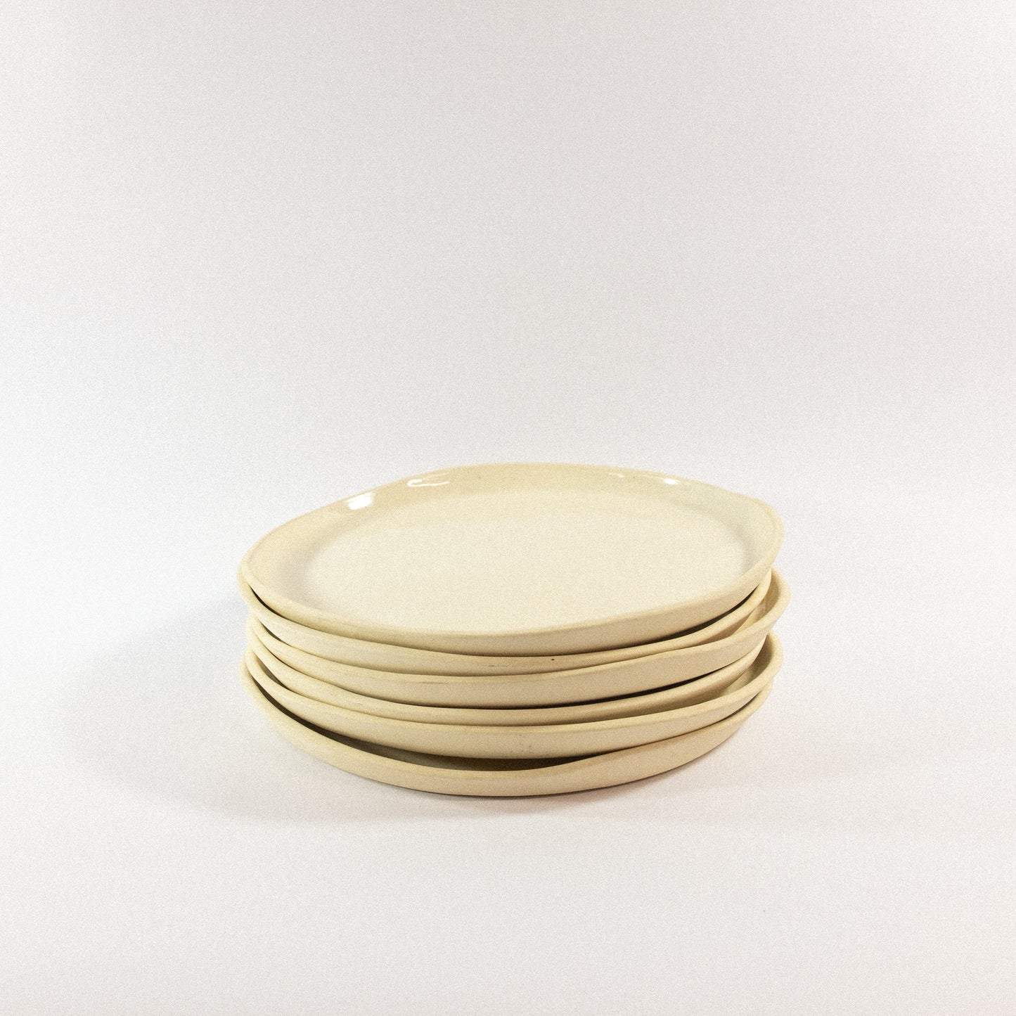 Handmade small porcelain dinner plates on a white background
