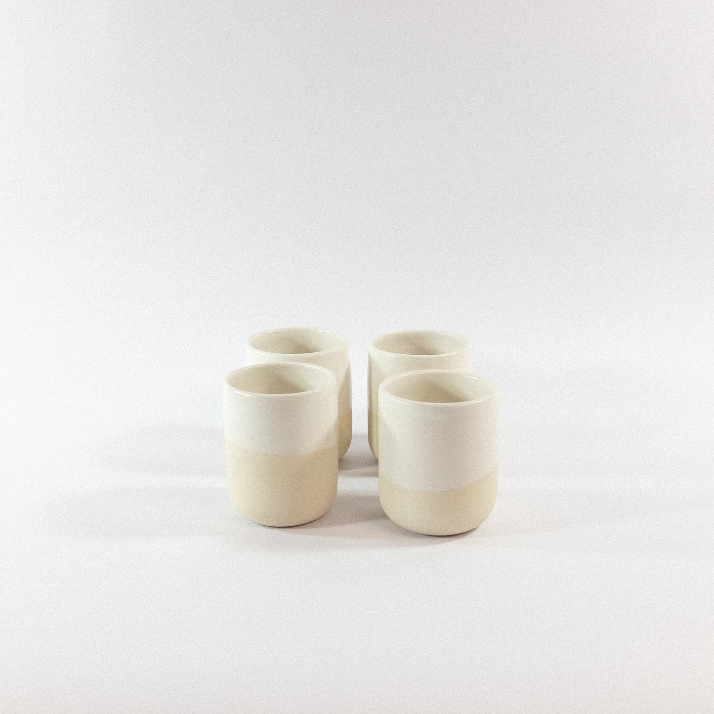 Four stoneware tumbler ceramic cups on a white  background