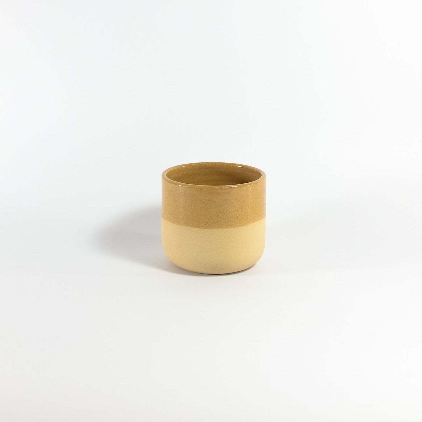 Caramel ceramic cup on a white background